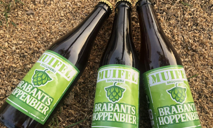 Drie flesjes Brabants hoppenbier liggend op de grond